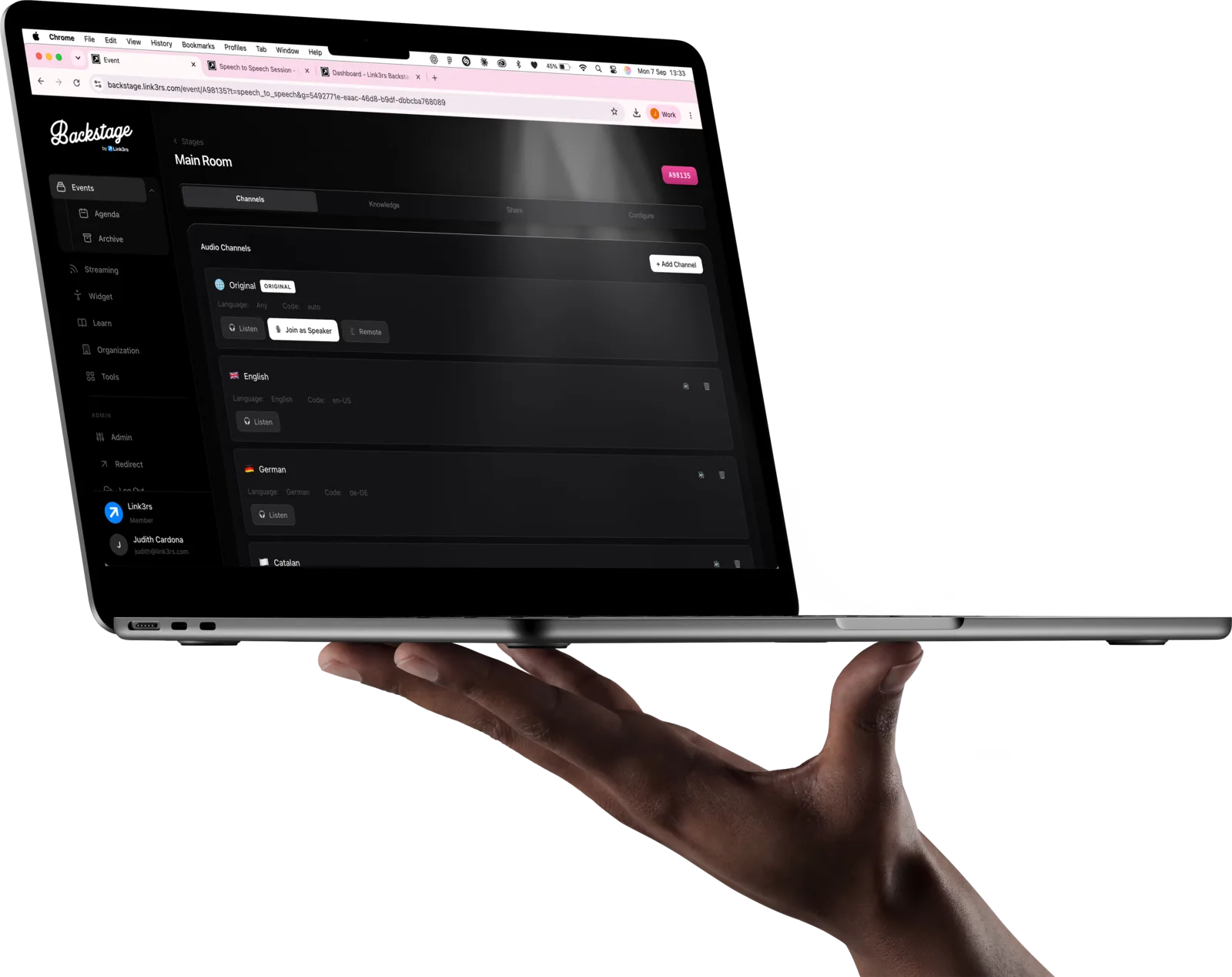 A hand holding a MacBook running Backstage